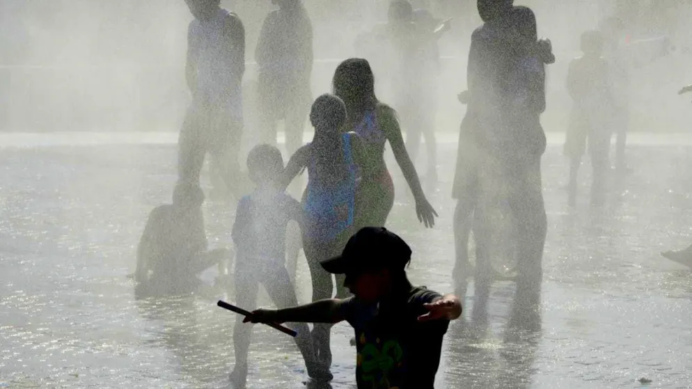 People cool off in a fountain in Madrid in hot weather. Photo: Paul White/AP/dpa/Archiv