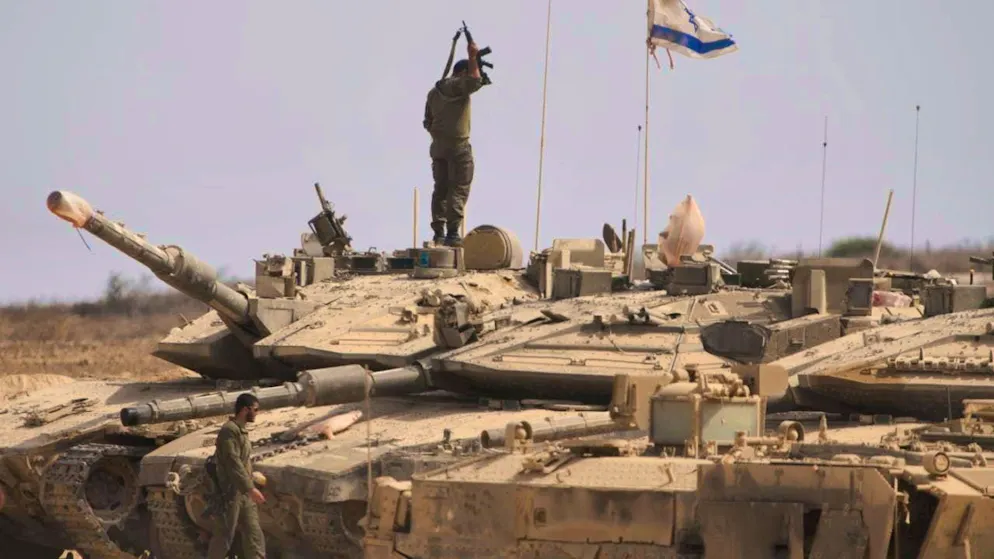 Israeli soldiers work on their tanks on the border with the Gaza Strip in southern Israel. Photo: Ariel Schalit/AP/dpa