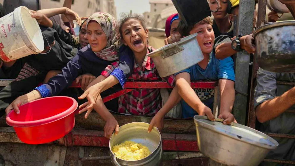 ARCHIVE - Palestinians fight for donated food in a community kitchen in the northern Gaza Strip. Photo: Jehad Alshrafi/AP/dpa