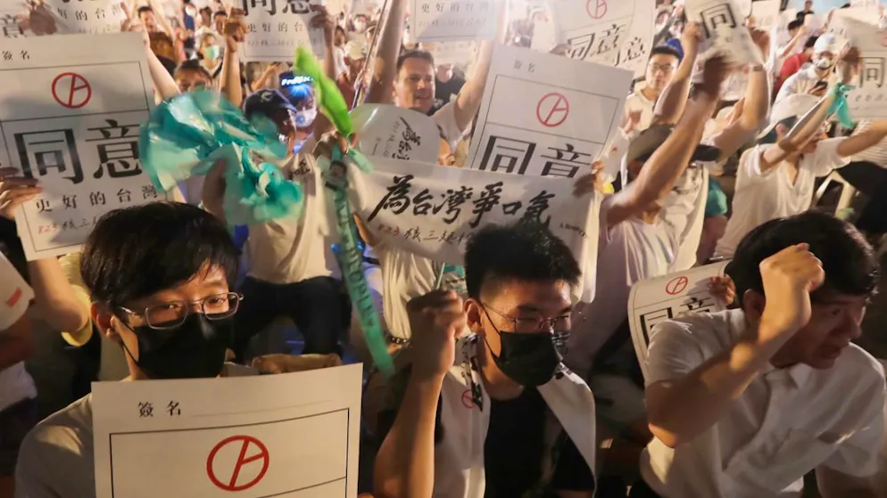 Menschen halten Schilder mit der Aufschrift «Approval» (Zustimmung), um ein Referendum zu unterstützen, das zugunsten der Verlängerung des Betriebs des dritten Kernkraftwerks in Taipeh, abgehalten wurde. Foto: ChiangYing-ying/AP/dpa