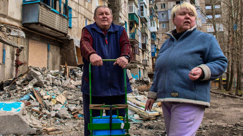 Residenti in piedi di fronte a un edificio residenziale danneggiato dagli attacchi di bombe russe sulla città di Kostyantynivka, nel Donbass, nell'Ucraina orientale, il 21 marzo 2025.