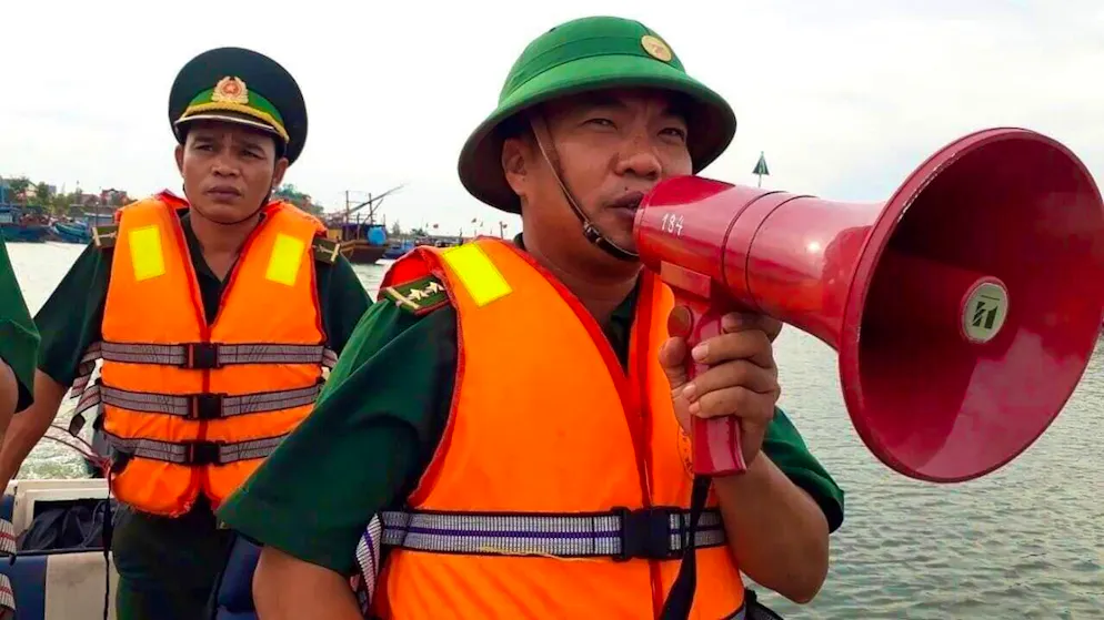 ARCHIVE - A coast guard officer speaks through a megaphone. Vietnam plans to evacuate 500,000 people. Photo: Nguyen Duc Tho/VNA/AP/dpa