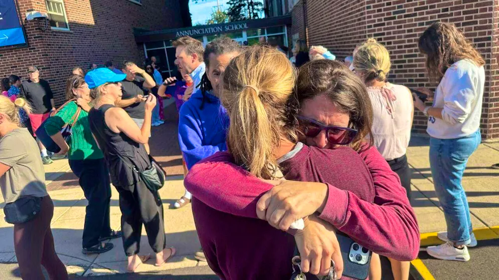 dpatopbilder - Parents stand outside a Catholic school. A shooting incident has occurred at a school in Minneapolis. Photo: Richard Tsong-Taatarii/Star Tribune/AP/dpa