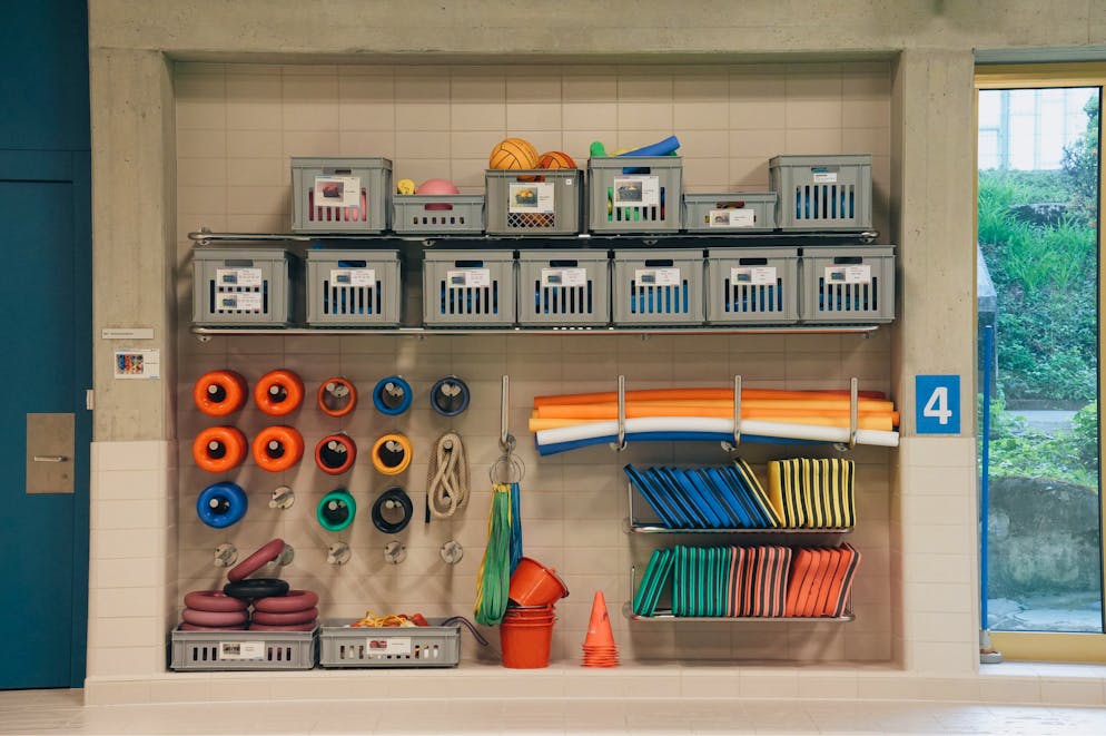 Die Teilnehmer*innen des Schwimmkurses gewöhnen sich mit Schwimmnudeln und anderen Hilfsmitteln Schritt für Schritt ans Wasser.