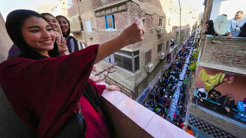 ARCHIVE - Egyptian girls pose for a selfie during an "iftar" during the holy month of Ramadan in Ezbet Hamada in the Cairo district of El Matareya. Photo: Amr Nabil/AP/dpa (archive photo)