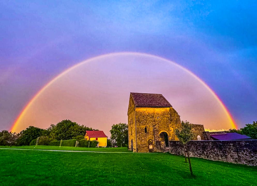 The ruins of the former Cluniac priory in Rüeggisberg are illuminated by a rainbow.