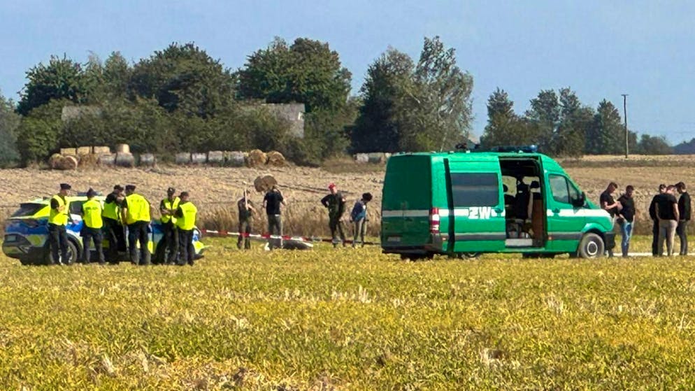 Polizei und Militärpolizei sichern Teile einer beschädigten Drohne, die von polnischen Behörden abgeschossen wurde, auf einem Gelände in Wohyn.