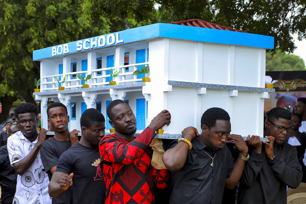 Alcuni uomini trasportano la bara decorata per l'ex proprietario di una scuola, durante il suo funerale, ad Accra, in Ghana, sabato 26 luglio 2025.