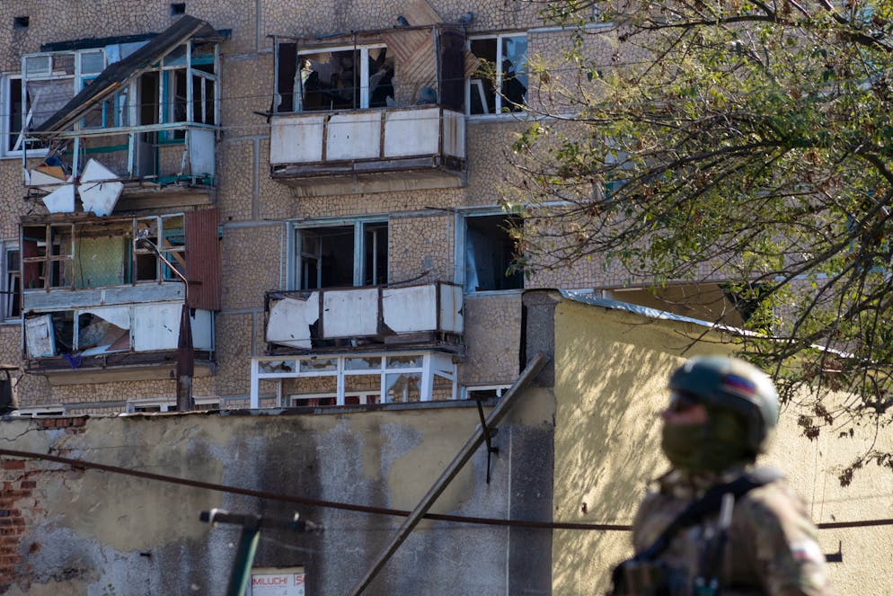 Un officier de la police militaire russe se tient à côté d'un immeuble résidentiel endommagé à Kurakhove, dans la région de Donetsk contrôlée par la Russie en Ukraine, le 27 septembre 2025, alors que le conflit russo-ukrainien fait rage. (Archives))