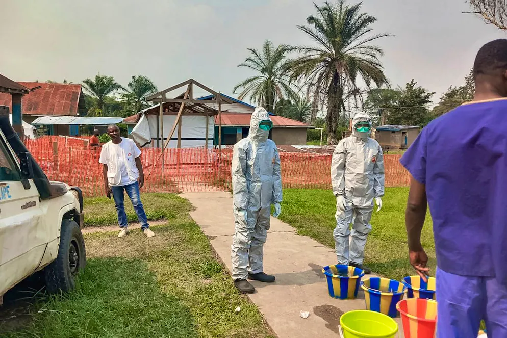 Sur cette photo fournie par Médecins Sans Frontières, des hommes se tiennent devant un centre de traitement Ebola dans la zone sanitaire isolée de Bulape, province du Kasaï, République démocratique du Congo, le 7 septembre 2025, qui a été mis en place à la suite de l'épidémie du virus Ebola de souche Zaïre. (MSF via AP, fichier)