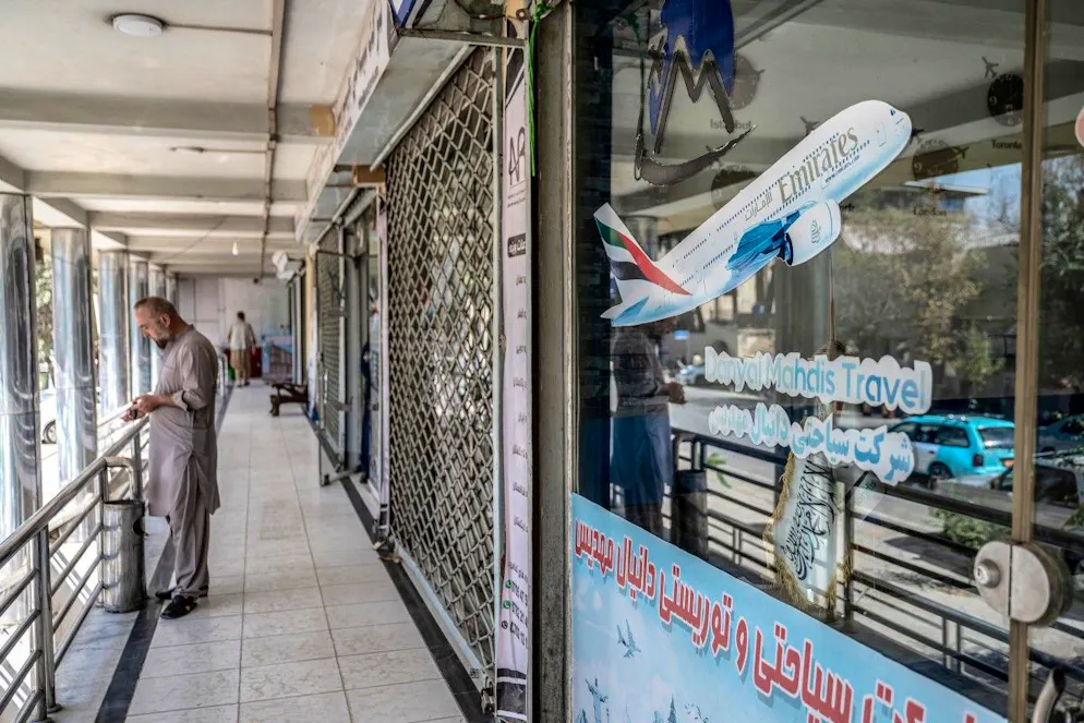 Un afghan se tient devant le bureau de son agence de voyage en pleine panne nationale des télécommunications, à Kaboul, le 30 septembre 2025.