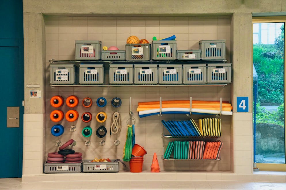 The participants in the swimming course get used to the water step by step with swimming noodles and other aids.