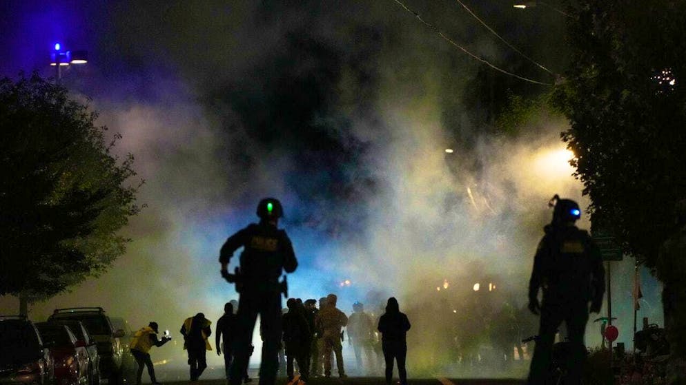 dpatopbilder - Police officers stand in front of a US Immigration and Customs Enforcement facility. Photo: Jenny Kane/AP/dpa