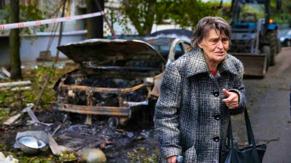 dpatopbilder - An elderly woman next to a destroyed car in Zaporizhia. photo: Kateryna Klochko/AP/dpa