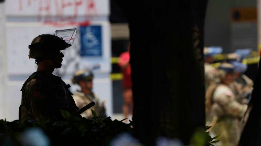 ARCHIV - Beamte der Nationalgarde stehen in der Nähe des Metropolitan Detention Center in Los Angeles und überwachen Proteste. Foto: Etienne Laurent/AP/dpa/Archiv