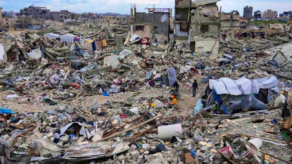 ARCHIVE - People walk amid the rubble of houses destroyed by the Israeli army's air and ground offensive against Hamas in the northern Gaza Strip in April. Photo: Abdel Kareem Hana/AP/dpa
