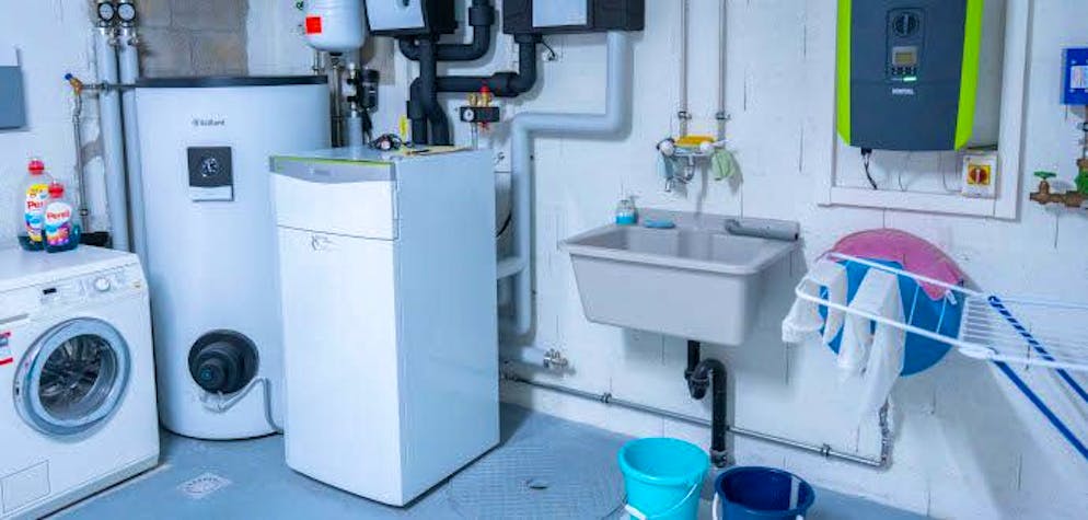 Grâce à un conseil incitatif au système de chauffage optimal. Installation de la pompe à chaleur géothermique avec sondes verticales, compteur et chauffe-eau dans la buanderie.