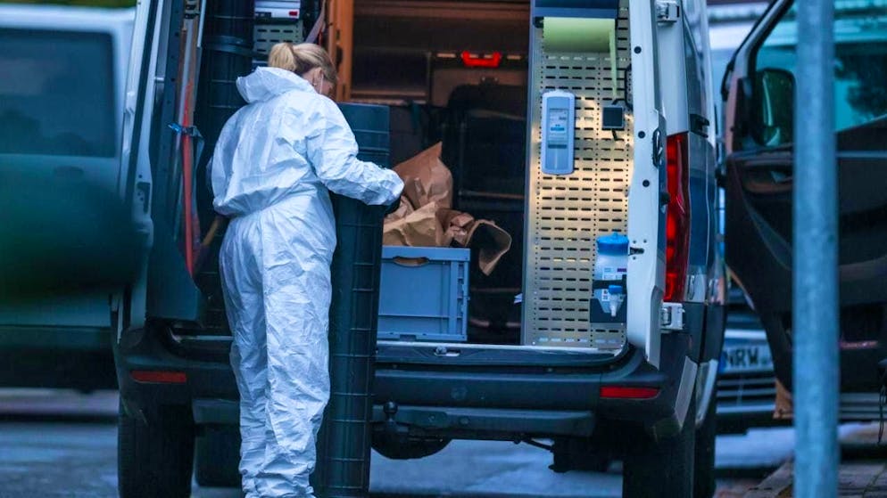 An officer in a forensic suit is on duty during the police forensic investigation. Photo: Christoph Reichwein/dpa