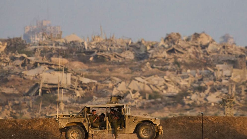 Israelische Soldaten ruhen sich in einem Fahrzeug auf einem Hügel über dem Gazastreifen im Süden Israels aus. Im Gazastreifen im Nahen Osten herrscht seit zwei Jahren Krieg. Am Montag wollen die Beteiligten über einen Friedensplan sprechen. Foto: Ariel Schalit/AP/dpa