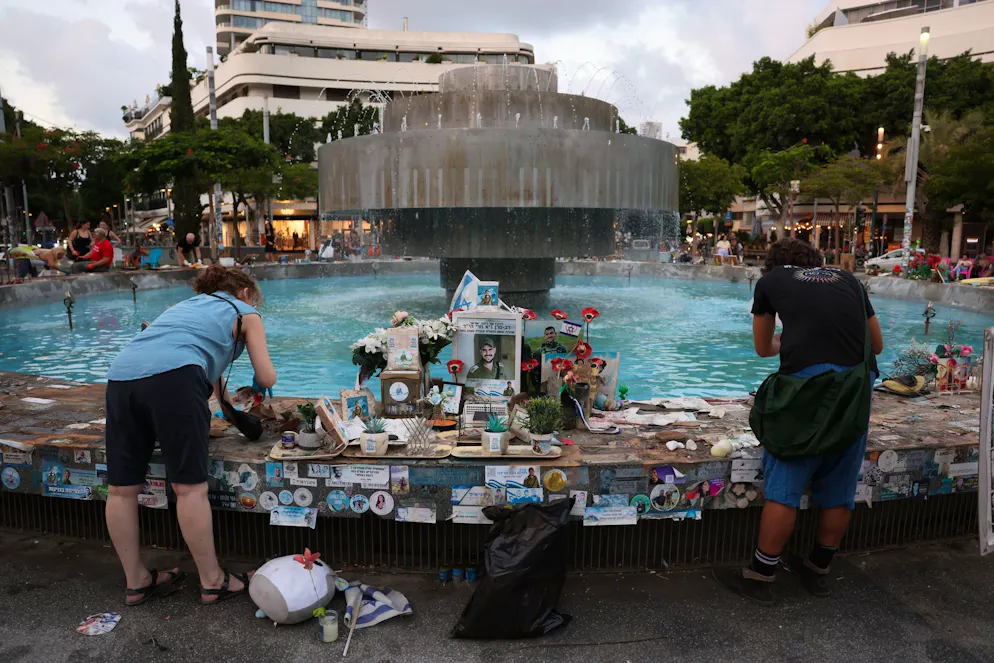 Des personnes nettoient les photos et les monuments commémoratifs des victimes israéliennes de l'attaque du 7 octobre à la fontaine de la place Dizengoff à Tel Aviv, Israël, le 5 octobre 2025. Deux ans après que la place publique soit devenue un lieu de commémoration, les gens la nettoient et remplaceront les objets le 7 octobre, à l'occasion du deuxième anniversaire de l'attaque du Hamas.