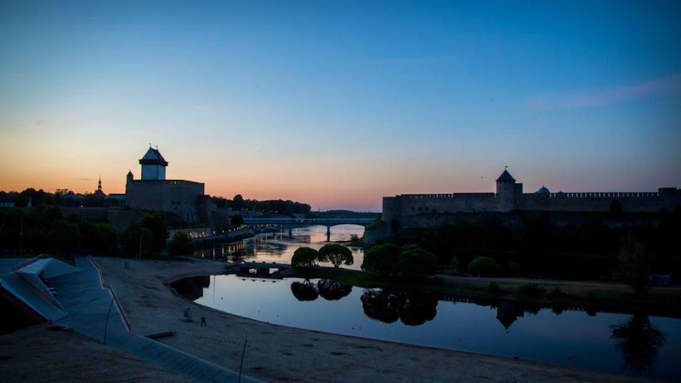 ARCHIV - Die Sonne geht am 01.06.2016 hinter der Hermannsfeste (l) in der estnischen Stadt Narva und der russischen Burg Iwangorod auf der gegenüberliegenden Seite unter. Foto: Kay Nietfeld/dpa
