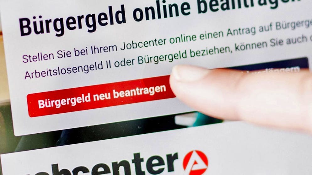 ARCHIV - Eine Frau tippt auf einem Tablet auf einen Link zum Beantragen des Bürgergeldes im Kundenbereich im Jobcenter Berlin-Mitte. Foto: Carsten Koall/dpa