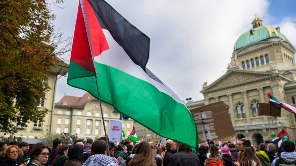 Des personnes tiennent des banderoles et agitent des drapeaux palestiniens sur la Place fédérale devant le bâtiment du Parlement lors d’un rassemblement non autorisé en solidarité avec le peuple palestinien à Berne samedi.