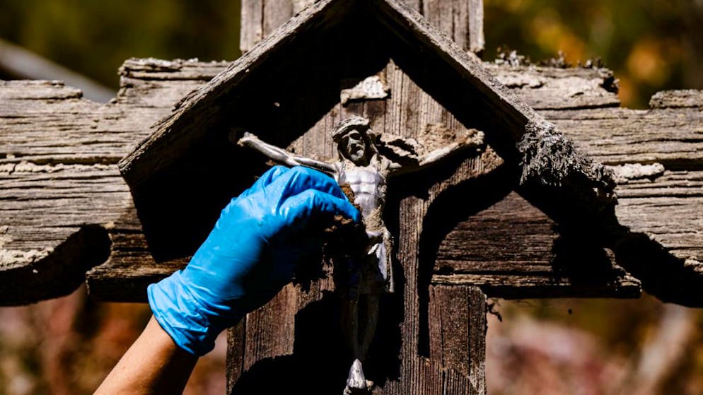 Freiwillige reinigen Weissenried nach Bergsturz in Blatten VS - Gallery. Die teils zerbrechlichen Denkmäler müssen sorgfältig und von Hand vom Dreck befreit werden.