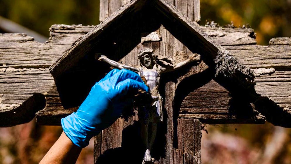 Volunteers clean Weissenried after landslide in Blatten VS - Gallery. The sometimes fragile monuments have to be carefully cleared of dirt by hand.