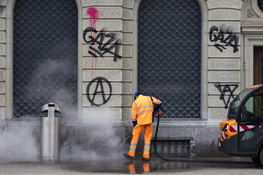 Ein Mitarbeiter der Stadtreinigung reinigt am Tag nach der nicht bewilligten Demonstration für Gaza das Trottoir vor der Valiant Bank mit Wasserdampf.
