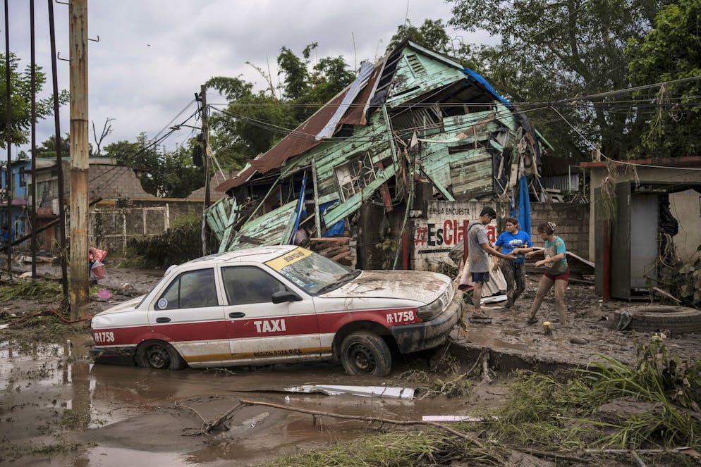 Des voisins se rassemblent autour d'une maison endommagée après de fortes pluies à Poza Rica, dans l'État de Veracruz, au Mexique, le samedi 11 octobre 2025. (AP Photo/Felix Marquez)