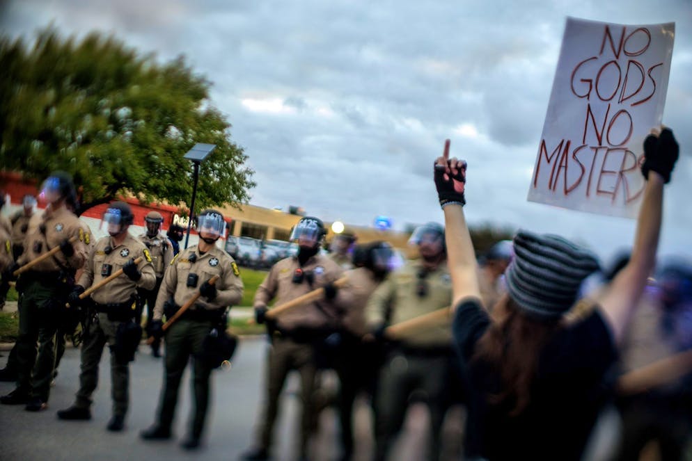 Un manifestant fait un geste et brandit une pancarte à l'intention de la police de l'État de l'Illinois lors d'une manifestation devant un centre de détention de l'ICE (Immigration and Customs Enforcement) à Broadview, dans l'Illinois, aux États-Unis, le 11 octobre 2025. Les manifestations contre l'ICE trouvent leur origine dans des préoccupations liées aux droits civils, à la sécurité des communautés locales et aux abus présumés des forces de l'ordre fédérales. EPA/CRISTOBAL HERRERA-ULASHKEVICH