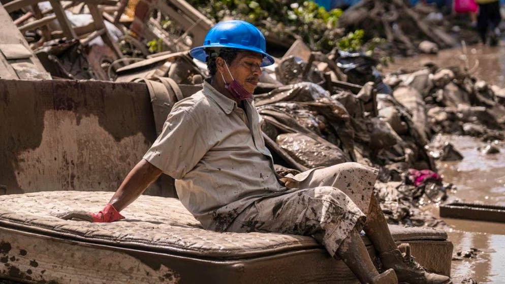 dpatopbilder - A man cleaning flooded houses takes a break. Photo: Felix Marquez/AP/dpa
