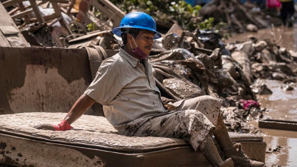 dpatopbilder - Ein Mann, der überflutete Häuser säubert, macht eine Pause. Foto: Felix Marquez/AP/dpa
