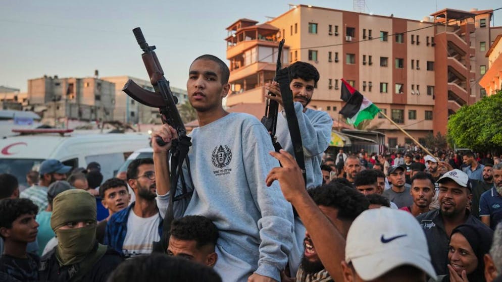 Palästinensische Gefangene tragen Gewehre nach ihrer Freilassung aus israelischen Gefängnissen. Foto: Abdel Kareem Hana/AP/dpa