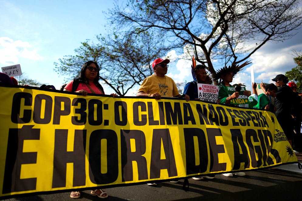 Des manifestants brandissent une banderole à Brasilia, au Brésil, le lundi 13 octobre 2025, sur laquelle on peut lire en portugais « COP30 : le climat ne peut pas attendre, il est temps d'agir », à l'approche du sommet des Nations unies sur le climat COP30. (AP Photo/Eraldo Peres)
