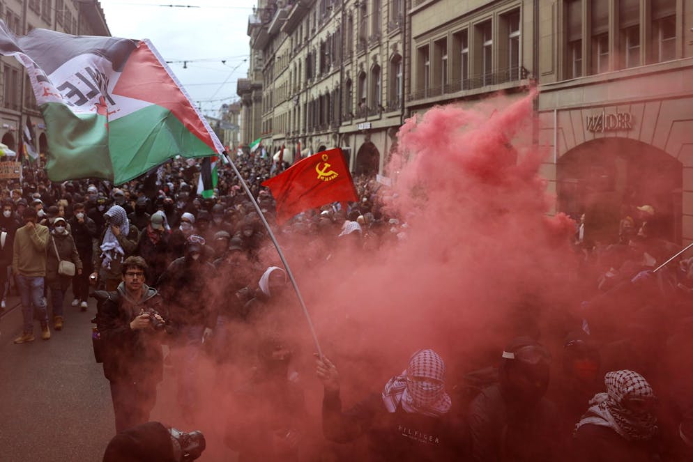 Des personnes brandissent des banderoles et agitent des drapeaux palestiniens lors d'un rassemblement non autorisé en solidarité avec le peuple palestinien à Berne, en Suisse, le 11 octobre 2025. (KEYSTONE/Peter Klaunzer)