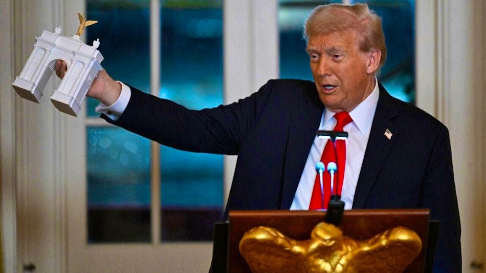 dpatopbilder - US President Donald Trump shows a model of a triumphal arch at a dinner for donors who contributed to the construction of the new White House ballroom. Photo: John McDonnell/AP/dpa