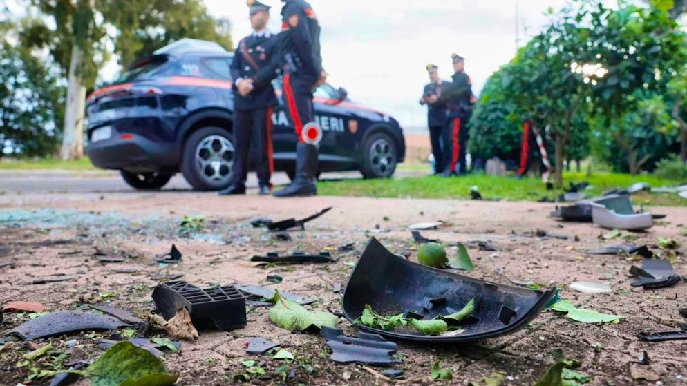 Car parts lie on the ground after an explosives attack, while Carabinieri of the military police stand in front of the house of investigative reporter Sigfrido Ranucci in the suburb of Rome. The background is unclear. No one was injured. Photo: Cecilia Fabiano/LaPresse via AP/dpa - ATTENTION: For editorial use only and only with full attribution of the above credit
