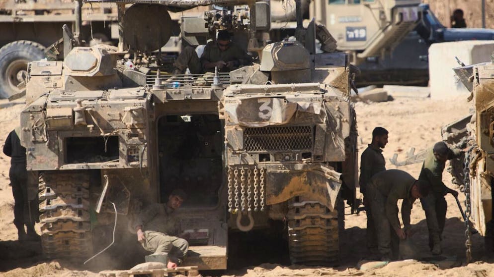 ARCHIV - Israelische Soldaten arbeiten an ihren Panzern an einem Sammelpunkt an der Grenze zum Gazastreifen im Süden Israels, nachdem Israel und die Hamas eine Pause in ihrem Krieg und die Freilassung der verbleibenden Geiseln vereinbart haben. Foto: Ariel Schalit/AP/dpa