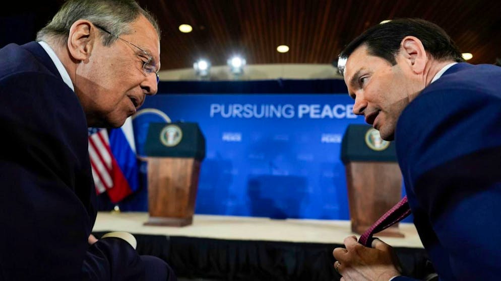 ARCHIV - US-Außenminister Marco Rubio zeigt seine Krawatte dem russischen Außenminister Sergej Lawrow vor einer Pressekonferenz mit US-Präsident Trump und dem russischen Präsidenten Putin auf der Joint Base Elmendorf-Richardson. Foto: Julia Demaree Nikhinson/AP/dpa