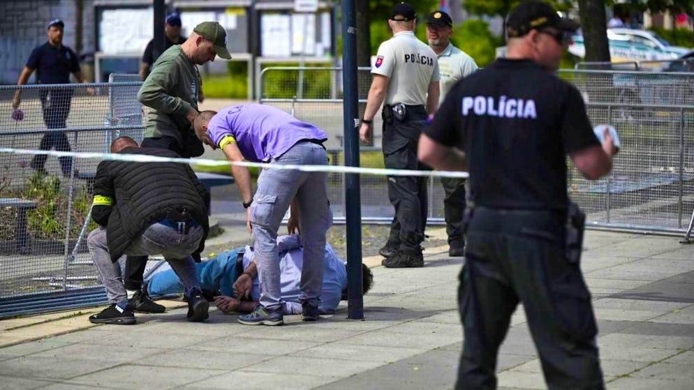 ARCHIVE - Police officers arrest a man after Slovak Prime Minister Fico was shot and injured after a cabinet meeting in the town of Handlova. Photo: Radovan Stoklasa/TASR Slovakia/AP/dpa
