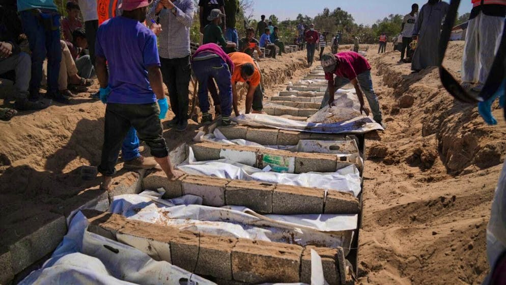dpatopbilder - The bodies of unidentified Palestinians are buried in a mass grave in the Gaza Strip. Photo: Jehad Alshrafi/AP/dpa