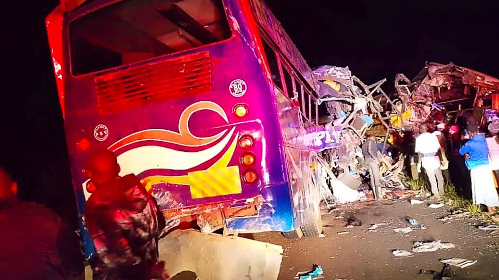 HANDOUT - Menschen versammeln sich an der Stelle, an der bei einem Zusammenstoß mehrerer Fahrzeuge in der Nähe von Gulu im Norden Ugandas mindestens 63 Menschen ums Leben gekommen sind. Foto: Uncredited/Uganda Red Cross/AP/dpa - ACHTUNG: Nur zur redaktionellen Verwendung und nur mit vollständiger Nennung des vorstehenden Credits