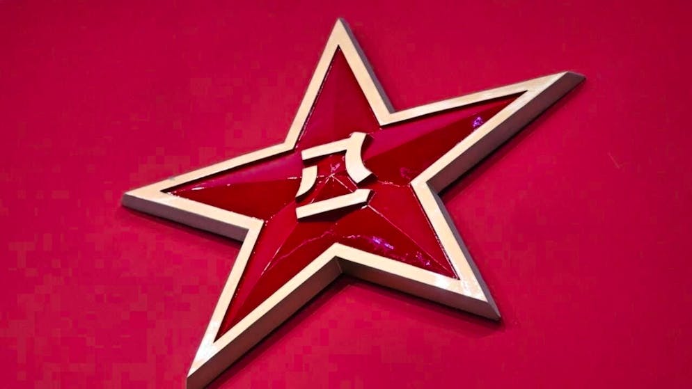 ARCHIVE - The logo of the Chinese People's Liberation Army is emblazoned on a red wall (archive photo). Photo: Johannes Neudecker/dpa