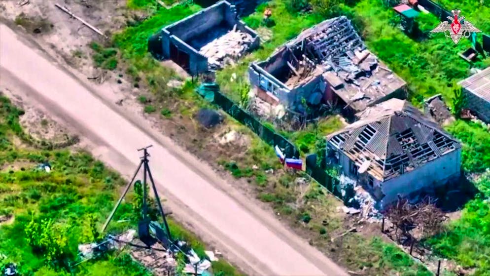 HANDOUT - In this still image taken from a video distributed by the Russian Defense Ministry Press Service via AP, two Russian soldiers hold Russian flags in a street after the village of Torske in the Donetsk region of Ukraine fell under the control of the Russian army. Photo: Uncredited/Russian Defense Ministry Press Service/dpa/Archive image - ATTENTION: For editorial use only and only with full attribution to the above credit