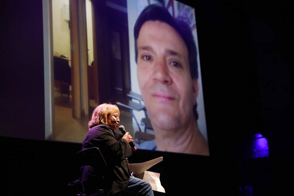 Des proches lisent des textes en mémoire des victimes lors d’un hommage organisé au théâtre Olympia de Valence, en Espagne, le 25 octobre 2025.