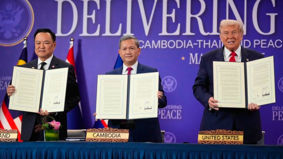 Präsident Donald Trump, der kambodschanische Premierminister Hun Manet (l) und der thailändische Premierminister Anutin Charnvirakul posieren mit ihren Dokumenten während einer Unterzeichnungszeremonie am Rande des ASEAN-Gipfels . Foto: Mark Schiefelbein/AP/dpa
