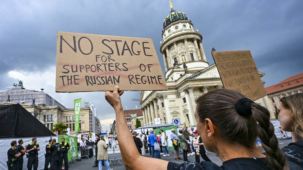 22.07.2025, Berlin: Mit einem Plakat «No stage for supporters of the russian regime» protestierten Menschen am 22. Juli 2025 gegen den Auftritt von Anna Netrebko in Berlin.