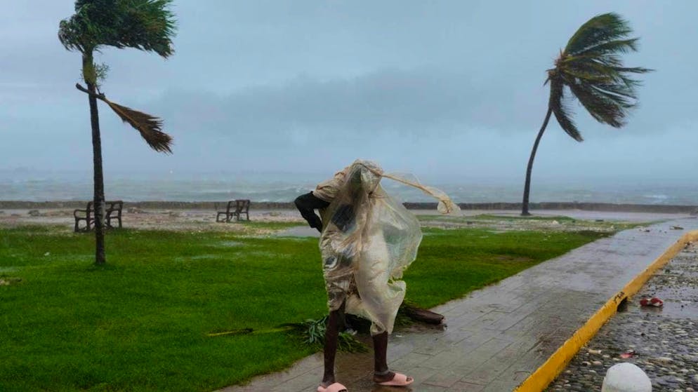 dpatopbilder - A man goes for a walk as Hurricane Melissa approaches. Photo: Matias Delacroix/AP/dpa